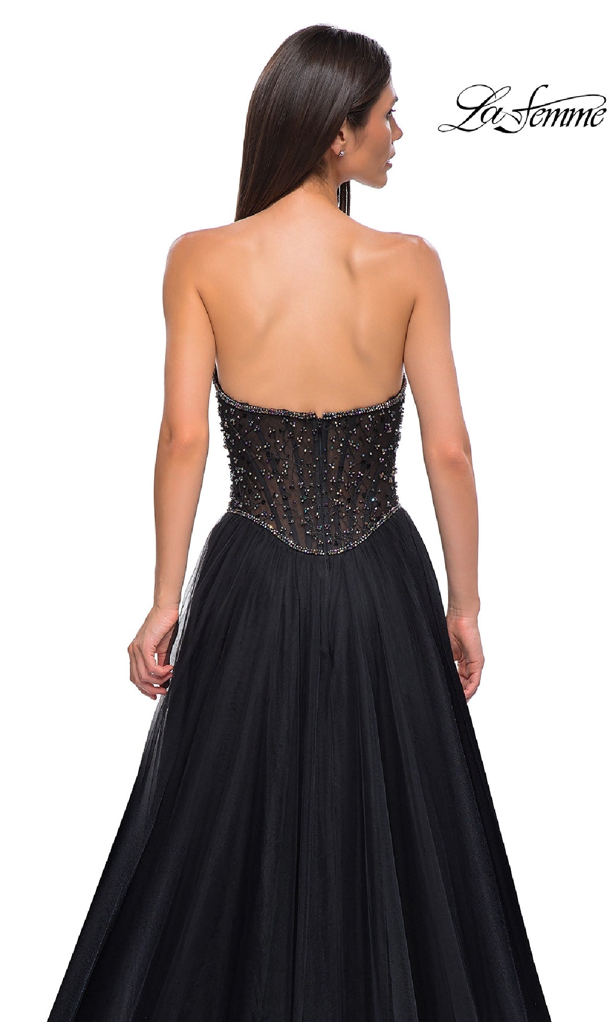 A woman models the Strapless Long Black Prom Ball Gown: La Femme 32856, featuring a sheer beaded bodice, photographed from the back against a plain white background.
